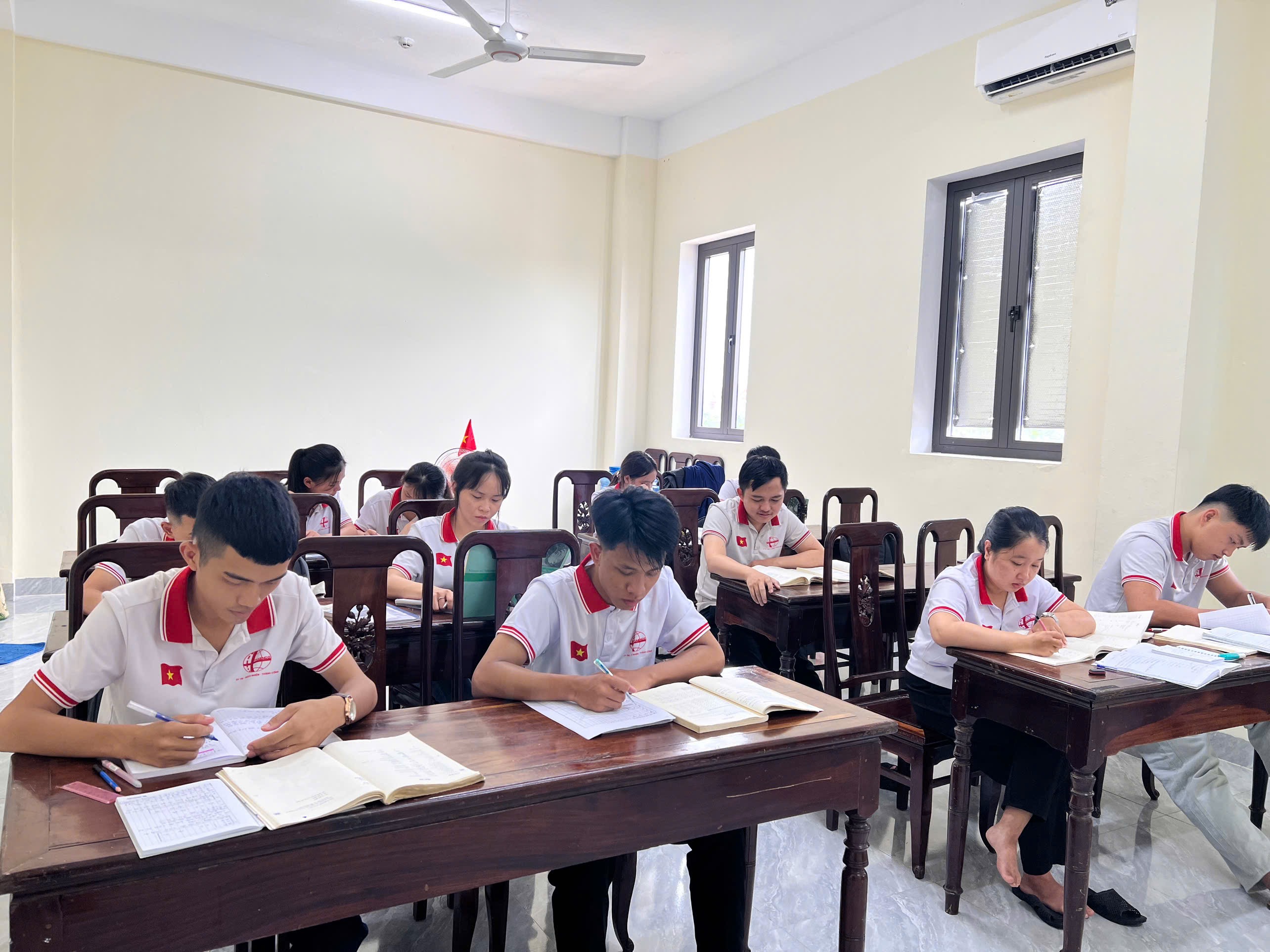 Học ngoại ngữ tại Traenco Edu: học viên đọc tài liệu và ghi chép trong lớp học